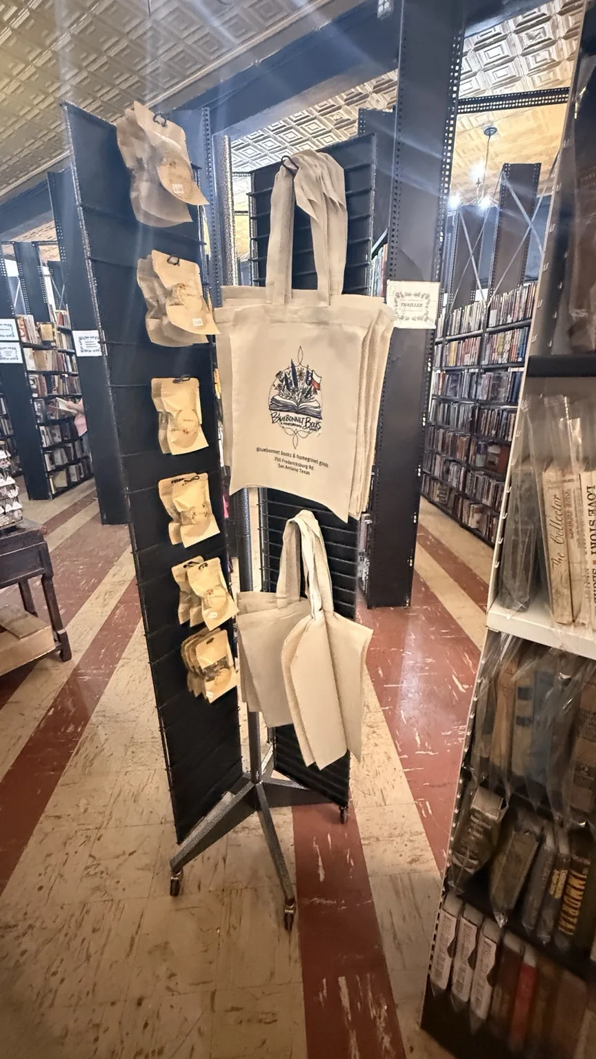 Store merchandise display with tote bags and small packaged goods.