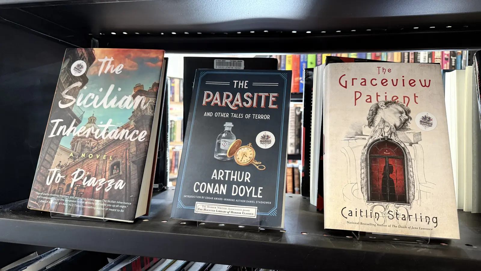 Mystery and horror shelf featuring The Sicilian Inheritance, The Parasite by Arthur Conan Doyle, and The Graceview Patient.